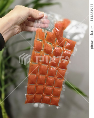 Hand Holding Orange Portion Pouches for Freezing Hand Holding Orange Portion Pouches for Freezing 133883911