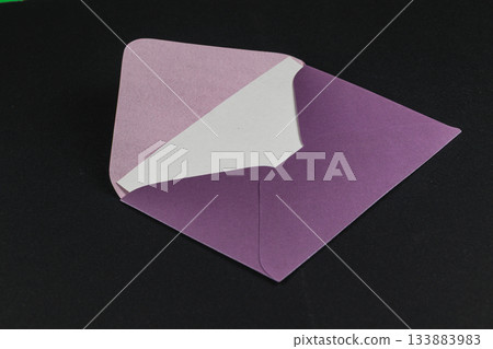 Colorful envelope with a purple interior displayed on a dark background 133883983