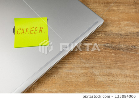 Sticky note with career reminder on laptop at home office desk 133884006