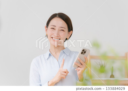 一位四十多歲的女性拿著智慧型手機 133884029