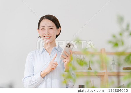 一位四十多歲的女性拿著智慧型手機 133884030