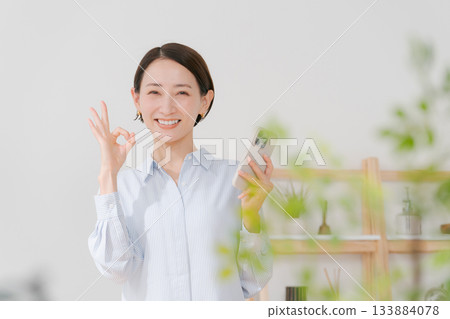 A woman in her 40s holding a smartphone A woman in her 40s holding a smartphone 133884078