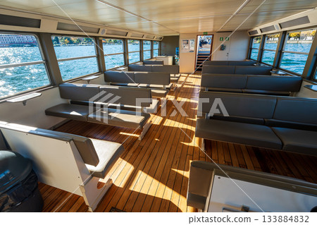 Interior of a sightseeing boat and view of the lake. Lugano, Ticino, Switzerland Interior of a sightseeing boat and view of the lake. Lugano, Ticino, Switzerland 133884832