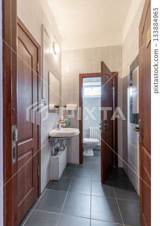 Small Tiled Restroom Interior with Sink and Toilet 133884965