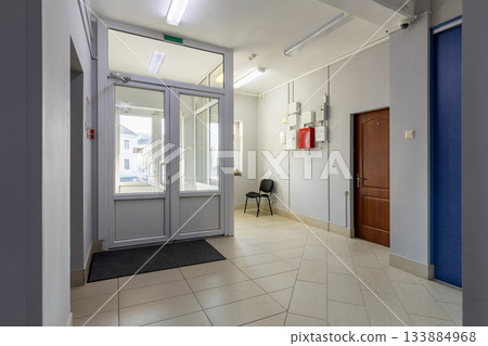 Bright Building Entrance Hall with Glass Doors and Utility Panels 133884968