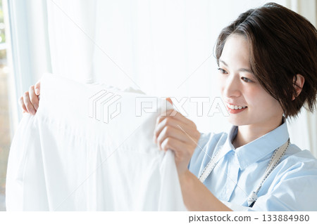 年輕的女士掛洗衣 133884980