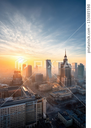 City sunrise scenes, Bright morning over skyscrapers, Sunrise illuminating urban glass structures brightly, Morning light bathes towering buildings amidst city hustle and bustle 133885598