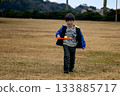 秋日公園裡，一個男孩在玩球 133885717