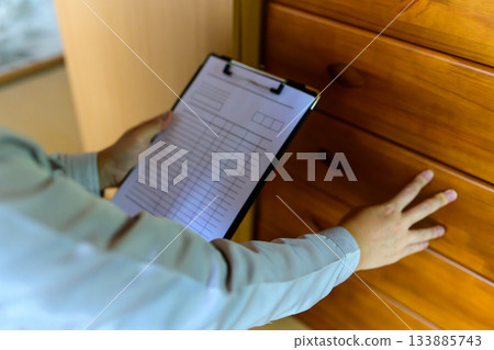 An expert who checks the condition of furniture and prepares an estimate An expert who checks the condition of furniture and prepares an estimate 133885743