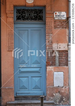 Vintage blue wooden door on red brick building. 133886256