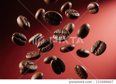 Freshly roasted coffee beans are captured in mid air, rich texture and deep brown color against warm background. This evokes sense of aroma and energy. 133886667