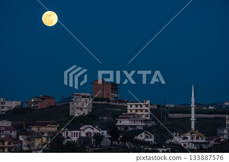 Full moon shines at night over small town in Balkans. Full moon shines at night over small town in Balkans. 133887576