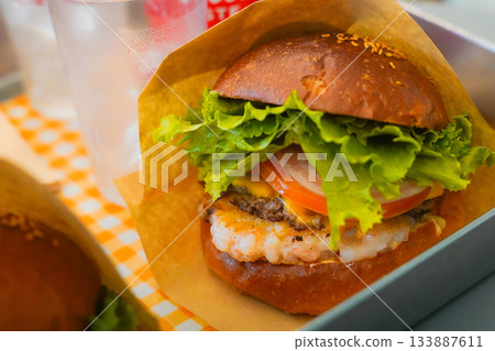 Delicious Handmade Shrimp Burger with Crispy Shrimp Patty and Fresh Vegetables 133887611