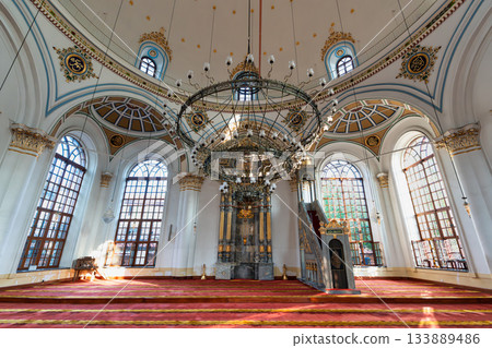 Ornate interior of Aziziye Mosque, Konya, Turkey, featuring mihrab, minbar, grand chandelier, and calligraphy. 133889486