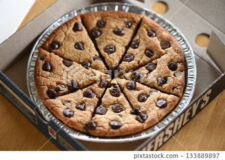 A chocolate cookie with a pizza-like appearance 133889897