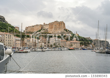 Aerial view marina cape Bonifacio south Corsica France citadel on rocky promontory on wild white limestone cliffs 133890343
