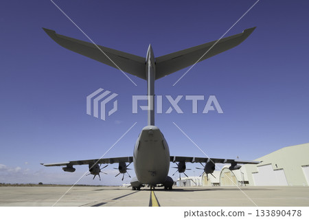 Rear view of large military transport aircraft on runway Rear view of large military transport aircraft on runway 133890478
