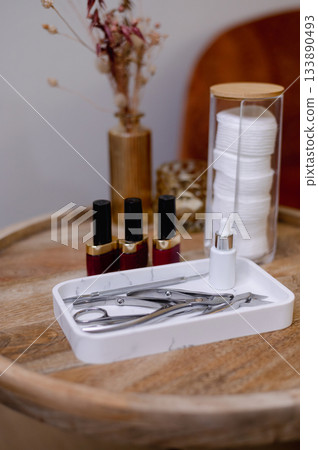 Detailed view of professional manicure procedure with nail care tools and hands in focus. Detailed view of professional manicure procedure with nail care tools and hands in focus. 133890493