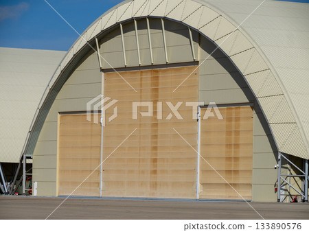 Aircraft hangar with large sliding door at air base Aircraft hangar with large sliding door at air base 133890576