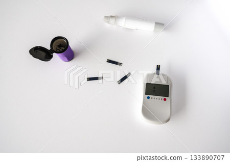 Close-up of a man's hands using a lancet on his finger to test blood glucose level. Concept of diabetes care, glycemia monitoring, and health management. 133890707