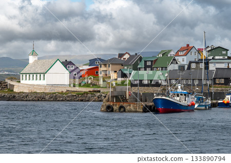 Scenic view of Nolsoy, Faroe Islands, with colorful fishermens houses by the sea, reflecting traditional Nordic charm and coastal lifestyle. 133890794