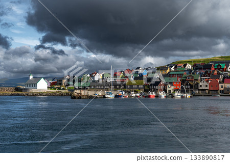 Scenic view of Nolsoy, Faroe Islands, with colorful fishermens houses by the sea, reflecting traditional Nordic charm and coastal lifestyle. 133890817