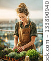 Woman gardening herbs on urban balcony at sunset 133890940