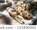 Chamomile essential oil bottle with fresh daisies 133890942