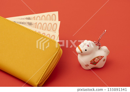 一個黃色錢包和一個馬的生肖擺件。象徵馬年的財富、金錢和經濟。 一個黃色錢包和一個馬的生肖擺件。象徵馬年的財富、金錢和經濟。 133891341