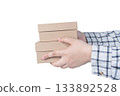 Hands of delivery man holding boxes isolated on white background. High quality photo 133892528
