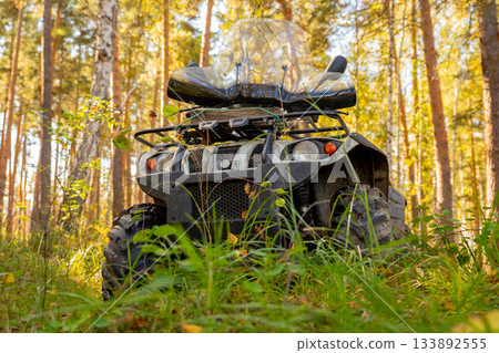 A real ATV in a summer forest on a sunny day. quad bike or quadbike, front view, bumper 133892555