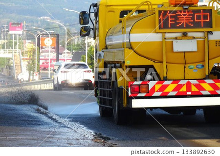 Working vehicle: A sprinkler truck cleaning the road Working vehicle: A sprinkler truck cleaning the road 133892630