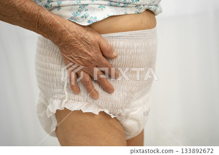 Asian senior woman patient wearing adult incontinence diaper pad in hospital. 133892672