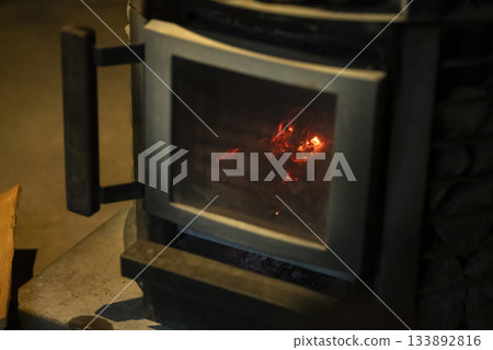 Firewood burning in a sauna stove 133892816