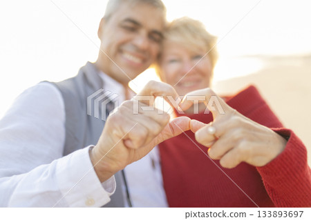 Senior couple hands forming heart shape expressing love Senior couple hands forming heart shape expressing love 133893697