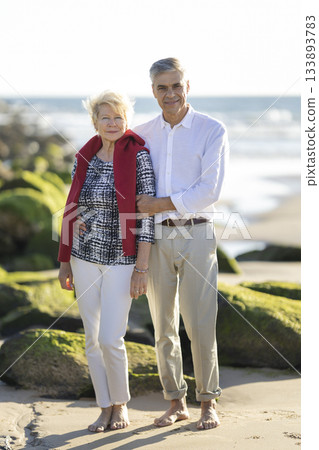 Happy senior couple enjoying beach vacation together Happy senior couple enjoying beach vacation together 133893783