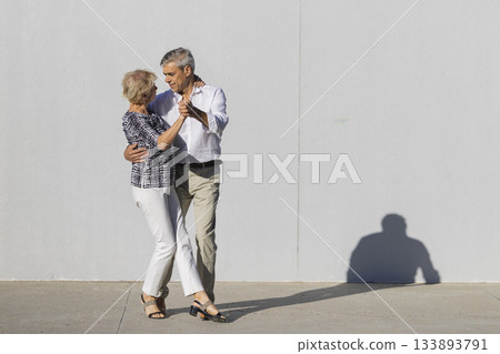 Senior couple dancing enjoying time together outdoors Senior couple dancing enjoying time together outdoors 133893791