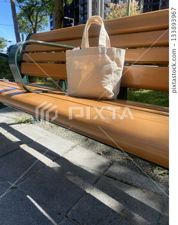 White Canvas Tote Bag on Park Bench in Sunlight 133893967