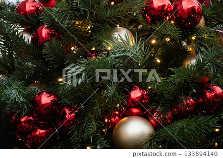 Christmas tree decorated red balls and lights garland. Xmas holiday spirit. Winter. Outdoors. Christmas tree decorated red balls and lights garland. Xmas holiday spirit. Winter. Outdoors. 133894140