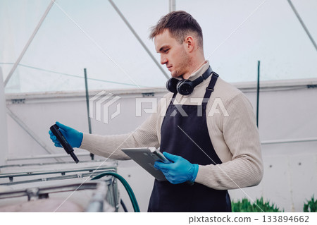 Physiologist analyzing tulip growth conditions carefully, Agricultural scientist conducting detailed experiments on tulips using specialized equipment and careful measurements 133894662