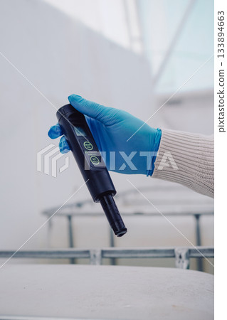 Scientist checks nutrient pH levels, Researcher measures plant solution pH accurately, Horticultural scientist precisely tests fertilizer and pesticide solutions in laboratory 133894663