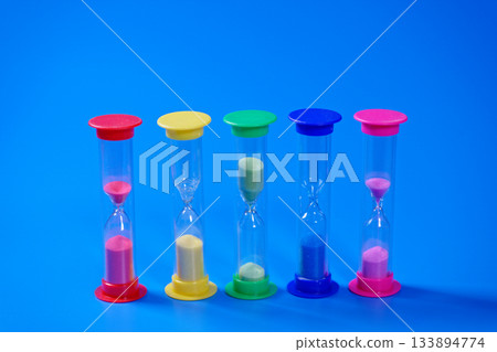 Hourglasses on blue background with copy space Hourglasses on blue background with copy space 133894774