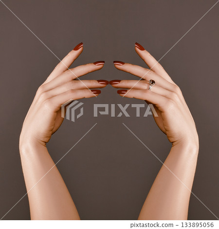 Elegant female hands with bright manicure. Square nails with red gel polish. Luxury fashion style of brilliants jewelry Elegant female hands with bright manicure. Square nails with red gel polish. Luxury fashion style of brilliants jewelry 133895056