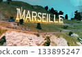 Miniature Marseille hillside sign with glowing letters at sunset 133895247