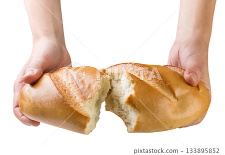 Loaf of bread in hands broken in half close-up on a white background. Isolated 133895852