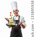 Excited Male Chef Happily Tossing Fresh Vegetables in a Hot Frying Pan Against Isolated White Background. 133895938