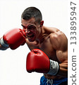 Furious Muscular Male Boxer Shouting While Throwing a Powerful Punch in Bright Red Gloves. 133895947