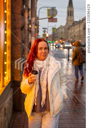 A Caucasian woman walks alone through a metropolis during the rain, tourism A Caucasian woman walks alone through a metropolis during the rain, tourism 133896429