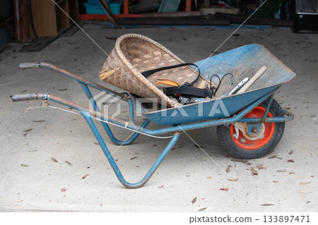 Wheelbarrows and work tools in the warehouse Wheelbarrows and work tools in the warehouse 133897471