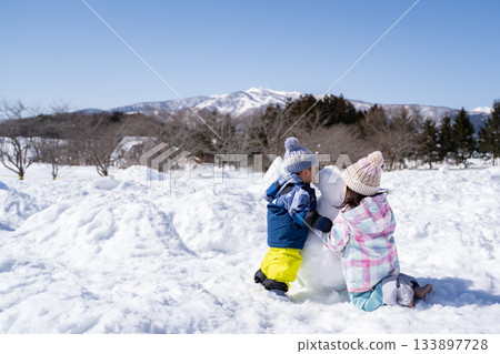 Children making a snowman Children making a snowman 133897728
